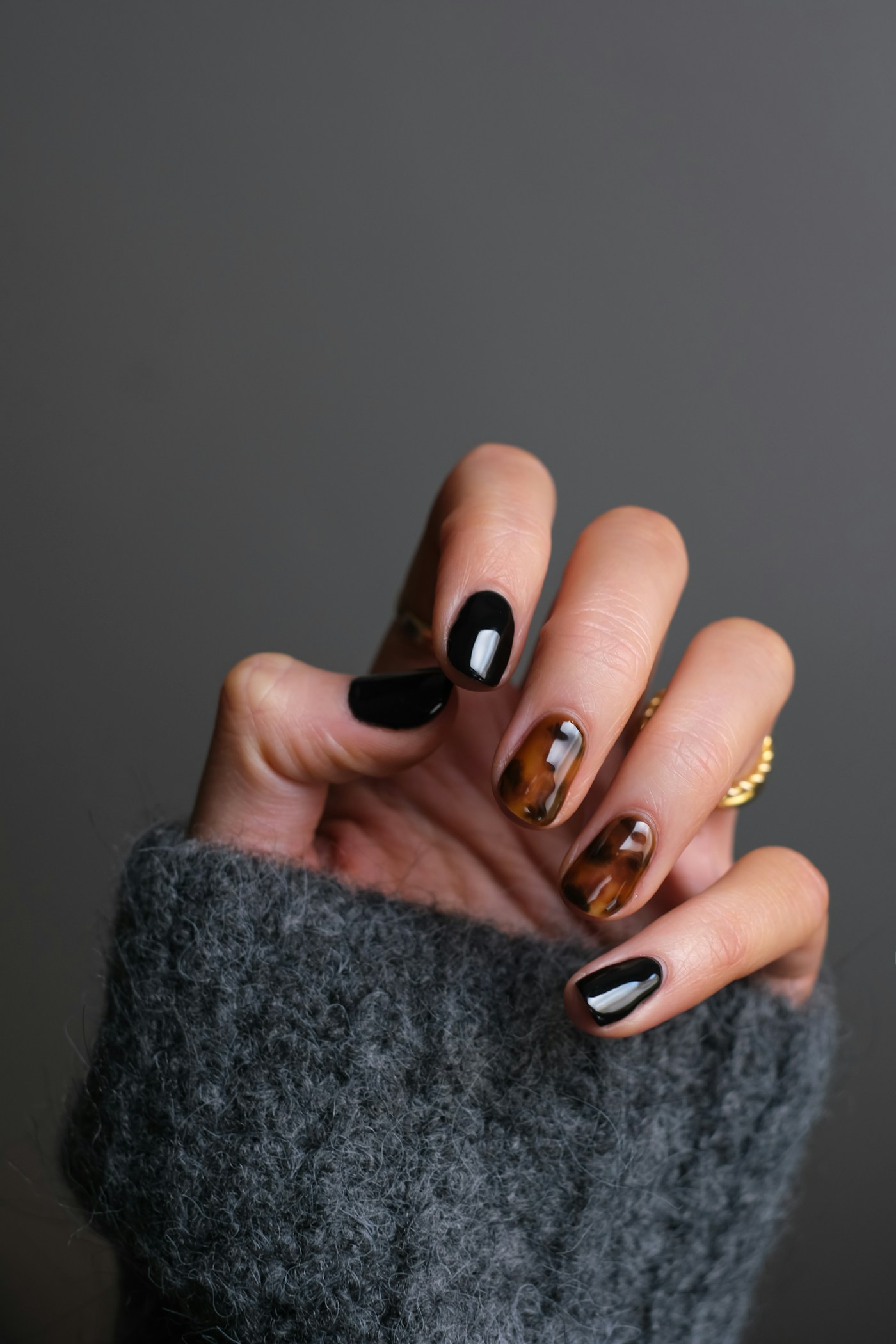 Glossy black and tortoiseshell manicure with intricate nail art